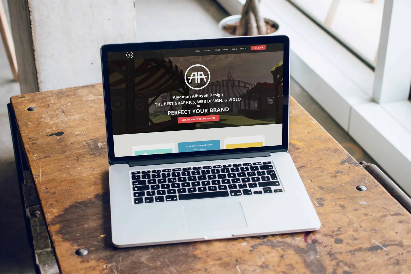 The Alyaman Alhayek Design website open on a MacBook on a wooden table.
