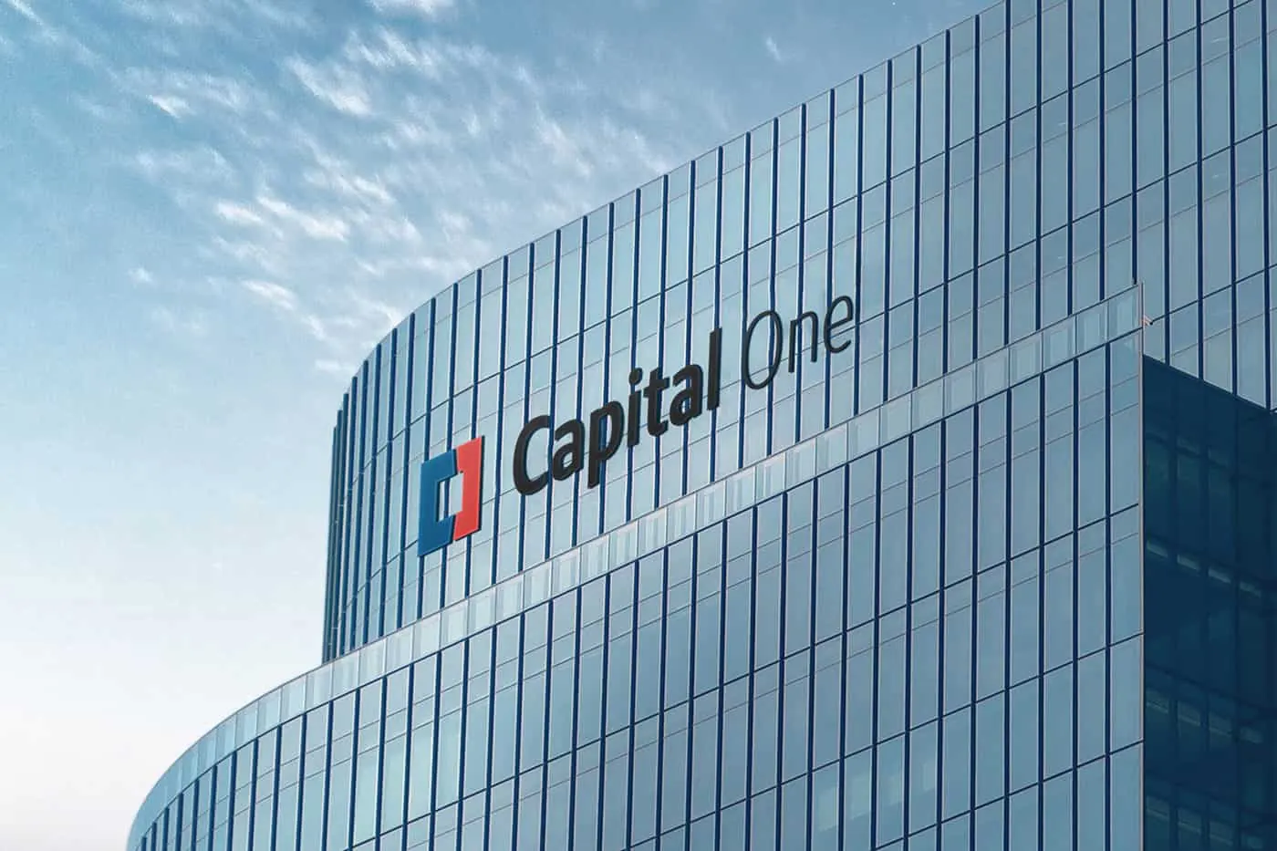 The new Capital One logo on the side of a glass office building.