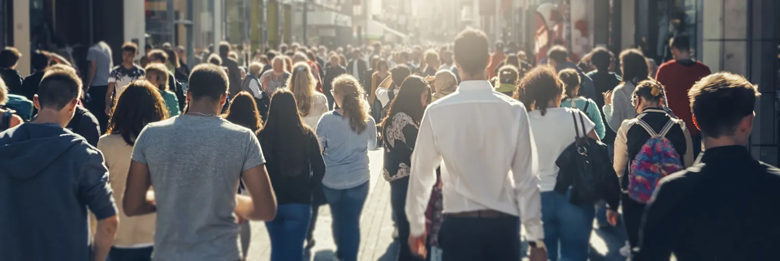 A large crowd of people walking down a busy city street.