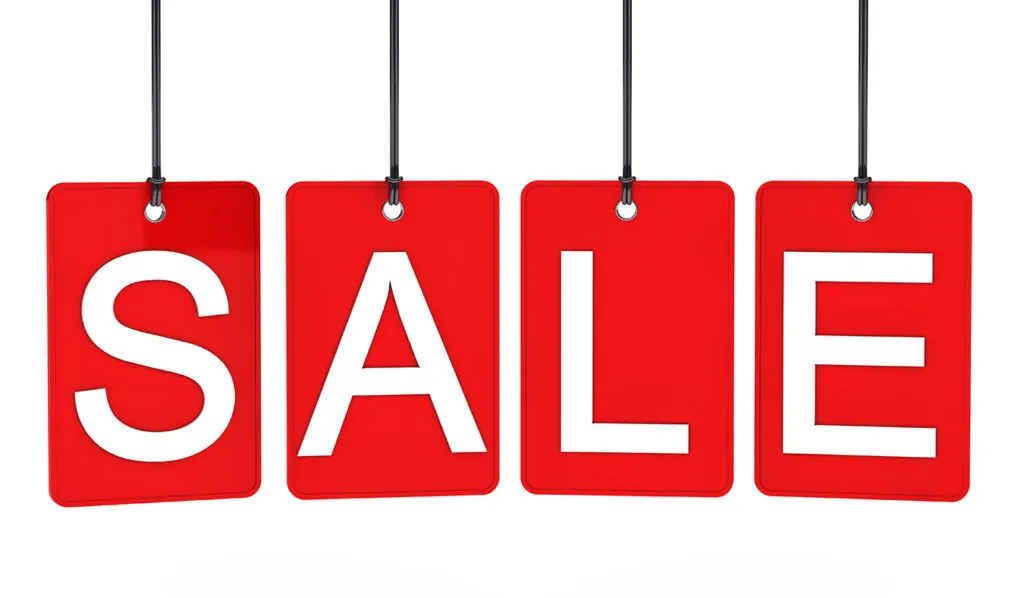 Red tags hanging on strings spelling the word Sale.