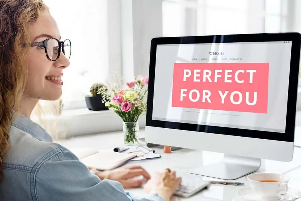 A smiling woman sits at a computer showing a Perfect for You page.