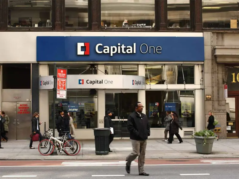 A Capital One bank branch on a busy city street with the new logo.