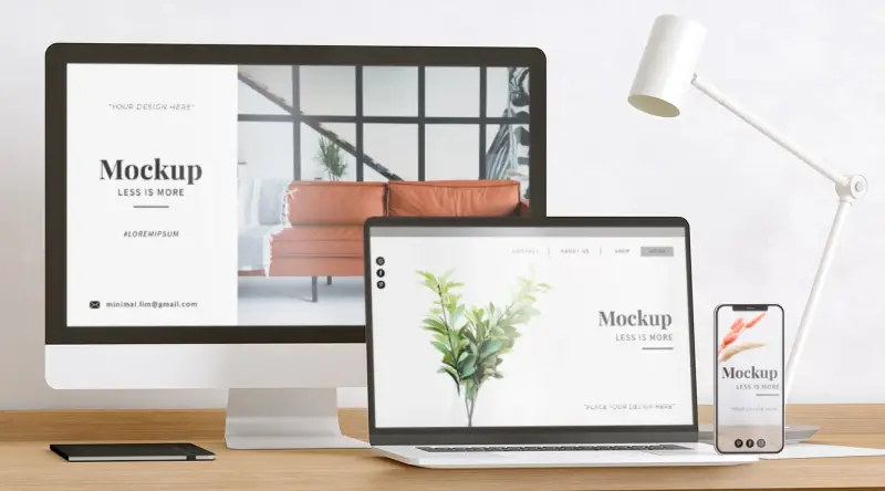 A website mockup on a desktop, laptop and phone beside a lamp.